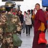 Die allgegenwärtige Staatsmacht zeigt Präsenz in Lhasa, während ein buddhistischer Mönch über den Platz eilt. Dieses Bild entstand 2011 – unabhängige Journalisten dürfen seit Jahren nicht mehr nach Tibet reisen. 