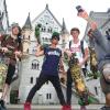 Geschafft: Simon Unger (l-r), Julien Bam, Felix von Laden und Cheng Loew posieren mit ihren Longboards vor dem Schloss Neuschwanstein bei Schwangau.