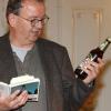Auch eine Bierflasche kann einem Kriminalkommissar bei der Spurensuche weiterhelfen: Richard Auer bei seiner Lesung in Lauingen. 	