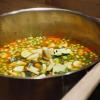Nach 15 Minuten Erbsen und Zucchini zur Suppe geben und weitere 15 Minuten köcheln lassen. 