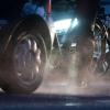 Ein Radfahrer steht neben einem Auto mit Dieselantrieb, dessen Abgase in der kalten Morgenluft sichtbar werden.