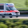 Ein Rettungswagen der Malteser fährt mit Blaulicht von der Unfallstelle mit einem Transporter.