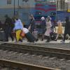 Menschen überqueren mit ihrem Gepäck die Gleise in Kramatorsk in der Region Donezk in der Ostukraine, um einen Zug nach Kiew zu nehmen.