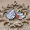 Zwei Wappen mit weiß-blauem Rautenmuster schmücken den Eingang zum Wertinger Schloss: links das kleine bayerische Staatswappen, rechts das Wappen des ehemaligen Landkreises Wertingen, das im oberen Wappenfeld einen staufischen Löwen abbildet. 