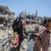 Einwohner von Gaza gehen durch die Trümmer, die ein israelischer Luftangriff hinterlassen hat.