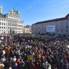 Demonstranten stehen in der Innenstadt vor dem Rathaus.