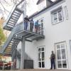 Bürgermeister Gerhard Mößner unten und die drei Mitarbeiter des Bauhofs auf der Treppe zeigen stolz die bisherigen Arbeiten an der Grundschule in Oberottmarshausen.