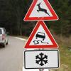 Warnschilder machen Autofahrer am Straßenrand auf Gefahren durch Schneeglätte und Wildwechsel aufmerksam. 