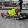 Ben Wilson liegt auf dem kalten Boden der Londoner Millennium Bridge auf seiner mitgebrachten Matte, umgeben von Farbtöpfchen.