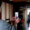 Der ukrainische Journalist Oles betritt die verlassene Wohnung seiner Eltern in Butscha. Sie befinden sich zu diesem Zeitpunkt hunderte Kilometer entfernt, sind aber trotzdem per Smartphone live dabei und im Display des Telefons zu sehen. 