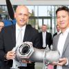Thomas Ehm, Vorsitzender der Geschäftsführung bei Premium Aerotec (links), übergab das Element aus dem 3-D-Drucker an Dirk Hoke (rechts), Geschaftsführer von Airbus Defence and Space. 	