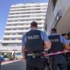 Polizisten stehen vor dem Hochhaus in Hanau, in dem ein totes Mädchen gefunden wurde. Vor dem Haus lag ein schwer verletzter Junge, der inzwischen ebenfalls gestorben ist.