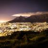 Tausende Lichter bilden einen Kontrast zum Tafelberg bei Nacht.