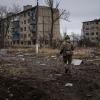 Ein ukrainischer Marinesoldat geht in Wuhledar an zerstörten Wohnblocks vorbei.