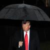 Ex-Präsident Donald Trump schütz sich mit einem Regenschirm vor einem Schauer. In Deutschland wird debattiert, was nötig ist, wenn der nukleare Schutzschirm der USA nicht mehr da ist. 