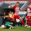 Bauchlandung für den FCA in Freiburg: Ruben Vargas blickt am Boden liegend zum Ball, während er vom Freiburger Yannik Keitel übersprungen wird. 
