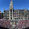 Zahlreiche Fans vom FC Bayern München feiern auf dem Marienplatz vor dem Rathaus mit den Spielern auf dem Balkon des Rathaus.