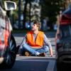 Ein Klimaaktivist sitzt in der Münchner Innenstadt auf der Fahrbahn und blockiert die Straße.