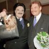 Zum 60. Geburtstag von Karl-Heinz Wildmoser, Präsident des Fußballvereins TSV 1860 München, gratuliert 1999 der Münchner Modezar Rudolf Moshammer (links) mit seinem Hund Daisy.