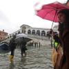 Passanten gehen in der Nähe der Rialto-Brücke durch das Hochwasser.