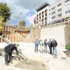 Der symbolische Grundstein für das Bauprojekt im Ulmer Dichterviertel wird gelegt. Im Hintergrund das bereits fertig gestellte Gebäude, in dem das Leonardo-Hotel, Büros und Wohnungen untergebracht sind. 	<b>Foto: Andreas Brücken</b>
