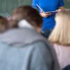 Ein Lehrer steht im Unterricht an der Tafel.