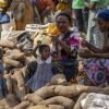 Junge Mädchen stehen bei ihren Müttern, die auf dem zweiwöchentlichen Karmo-Straßenmarkt in Nigeria Gemüse verkaufen.  Vielen Mädchen in Afrika wird ein Schulbesuch vorenthalten. 