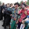 Zwei Teilnehmer in Clownskostümen stehen während der Demonstration "Grenzenlose Solidarität statt G20" neben Polizisten.