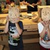 Die Holzmasken der Schnitzfreunde luden zu Späßen ein. 	