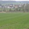 Auf dieser landwirtschaftlichen Fläche soll das neue Wohngebiet in Wörnitzstein entstehen. Im Hintergrund: die Wörnitz und die örtliche Kirche. 	