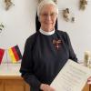Vom deutschen Botschafter in Albanien, Peter Zingraf, bekam Schwester Juditha die Auszeichnung überreicht.  	