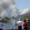 Mehrere Menschen schauen in La Londe-Les-Maures auf eine Rauchwolke, die über einem Wald aufsteigt. Hunderte Feuerwehrmänner sind im Einsatz um die zahlreichen Brände zu löschen. 