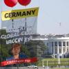 Ein Transparent vor dem Weißen Haus fordert Bundeskanzlerin Merkel dazu auf, ihre Ablehnung einer Sonderaussetzung für Impf-Patente aufzugeben.