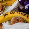 Prinz Harry und seine Frau Meghan halfen während ihres Besuchs der Hilfsorganisation One25 bei der Vorbereitung von Essenspaketen. Meghan schrieb auf Bananen Mut-Botschaften.