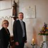 Christine Rotzer, Vorsitzende des Pfarrgemeinderates und Pater Georg Gantioler vor der Gedenktafel für Pater Blasius Mayer in der Altisheimer Kirche.