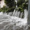 Wasser strömt auf eine Straße in Viktring bei Klagenfurt in Kärnten. Die Lage in Österreich bleibt am Sonntag angespannt.