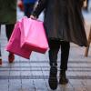 Eine Person geht nach dem Einkauf mit Tragetaschen durch eine Fußgängerzone. Bisher ist die deutsche Wirtschaft besser als erwartet durch die Krise gekommen.