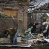 Anwohner beseitigen die Trümmer eines beschädigten Hauses nach russischem Beschuss.