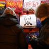 In einem Souvenirladen in Sankt Petersburg betrachten Frauen T-Shirts, auf denen die Buchstaben der UdSSR und Wladimir Putin abgebildet sind. 	