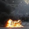 Demonstranten stehen während der Proteste in Marseille hinter einem brennenden Auto.