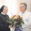 Mit einem Blumenstrauß bedankt sich Chefarzt Dr. Camill Herrmann bei seiner langjährigen Stütze in der Anästhesie Schwester M. Petra Rauscher. 