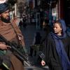 Ein Taliban-Kämpfer steht Wache, während eine Frau vorbeiläuft. Afghanistan erlebt unter den Taliban nach Angaben der Vereinten Nationen (UN) eine systematische Auslöschung von Frauenrechten. 