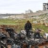 Männer stehen neben dem Wrack eines Militärhubschraubers der Regierung. Die Offensive syrischer Regierungstruppen auf die letzte große Rebellenhochburg um die Stadt Idlib treibt immer mehr verzweifelte Menschen in die Flucht.