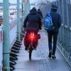 Radfahrer und Fußgänger teilen sich auf dieser Brücke in Köln einen schmalen Weg.