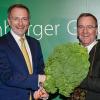 Christian Lindner (l) übergibt dem neuen Oldenburger Grünkohlkönig Boris Pistorius mit einer Grünkohlpflanze sein Ehrenamt.