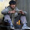 Ein Mann wärmt sich in Kabul an einem Ofen und hört Radio. Habib Khan (nicht der Mann im Bild) hat in Afghanistan als Rundfunkjournalist gearbeitet. Seit Kurzem lebt er in Dillingen.