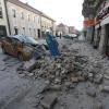 Trümmer eines durch ein Erdbeben eingestürzten Hauses bedecken ein Fahrzeug, das an einer Straße in Sisak steht.