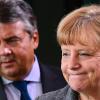 Kanzlerin Angela Merkel steht mit breitem Lachen vor einem ernsten SPD-Chef Sigmar Gabriel. Er kommt an ihr nicht vorbei.