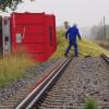 Mit Schaufeln müssen Männer Tonnen von Mais aus einem umgekippten Anhänger von der Bahnline Krumbach Mindelheim zwischen Aletshausen und Hohenraunau schaufeln. 	