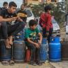 Palästinensische Kinder in Chan Junis stehen Schlange, um Flüssiggasflaschen aufzufüllen.